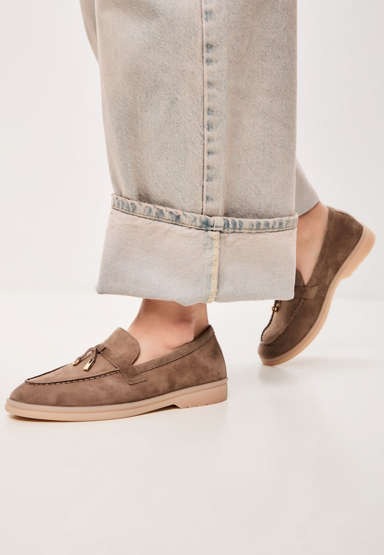 A pair of stylish women's moccasins in dark beige, featuring fashion-forward platform soles from Aurelia shoes.