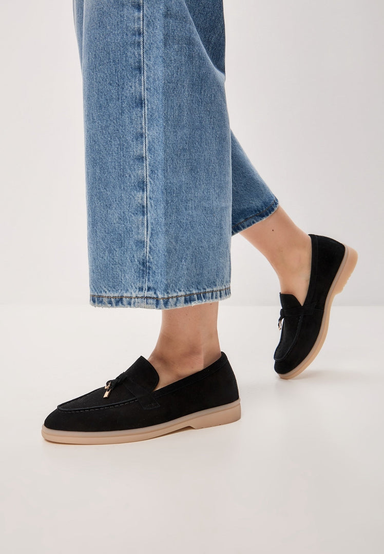A pair of stylish black platform moccasins, known as Aurelia moccasins, made of black leather - perfect women's platform shoes for a chic look.