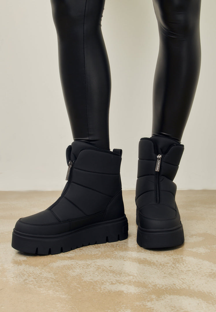A pair of stylish and elegant black snow boots, perfect for winter fashion.