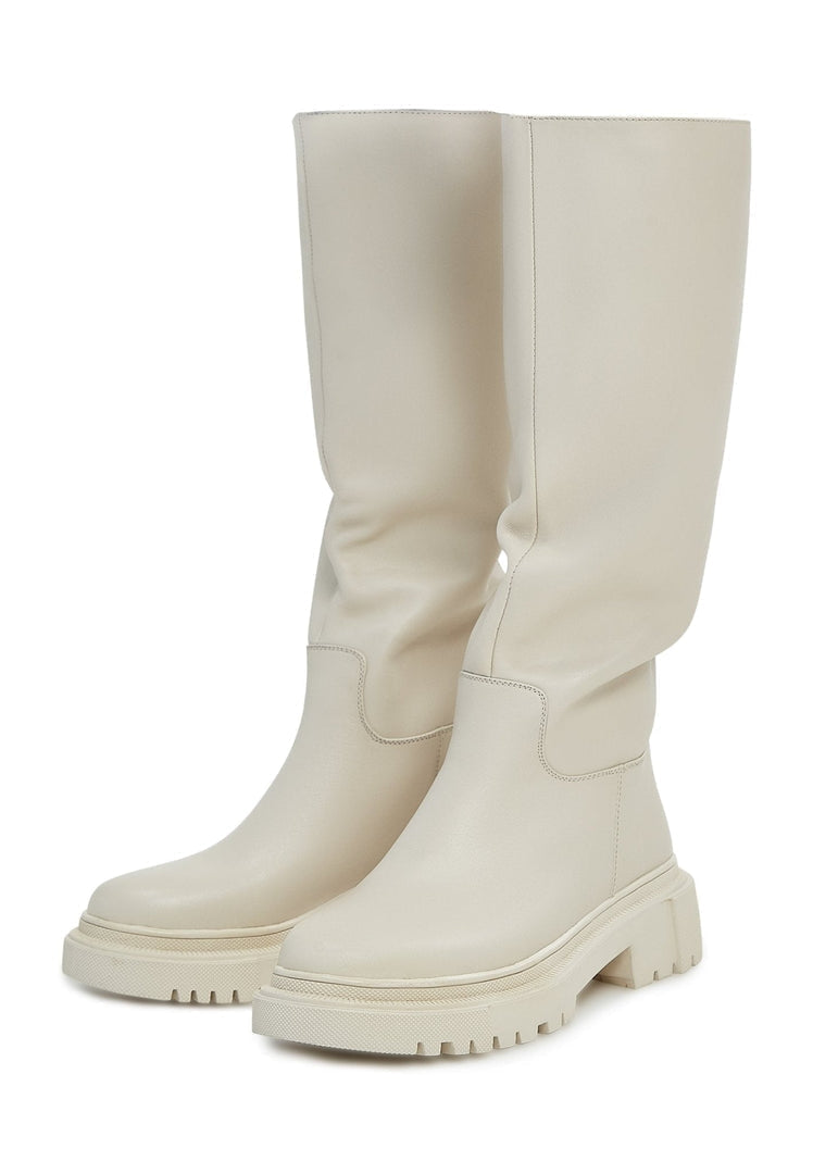 A woman wearing stylish knee-high leather boots in the color Anastasia beige, the perfect addition to any women's fashion wardrobe.