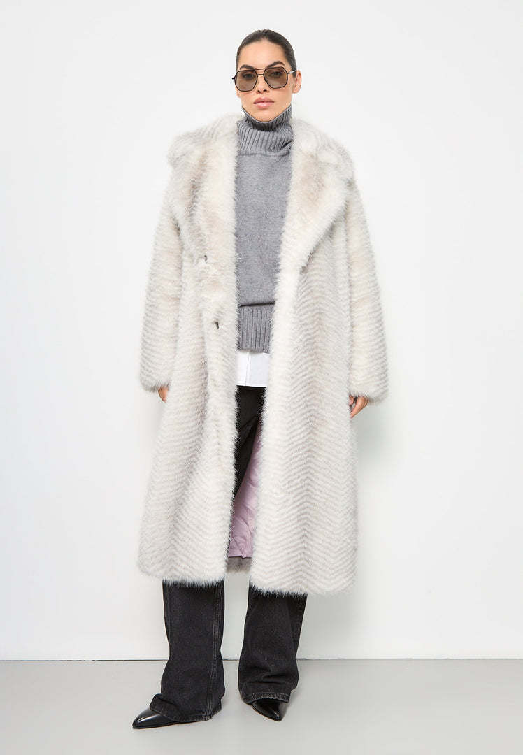 A woman wearing a luxurious faux fur coat, the Faux fur coat Natalie, in white. This high-end designer faux fur coat exudes elegance and style.