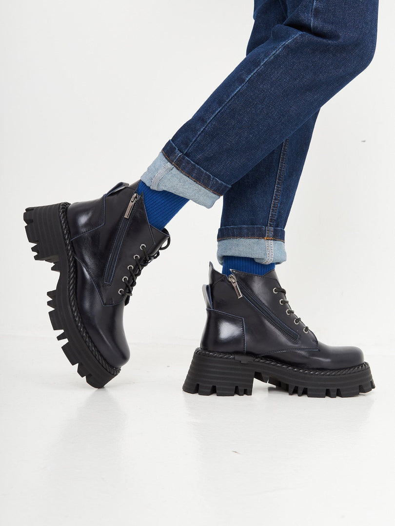A stylish pair of lace-up ankle boots in a trendy blue color, perfect for a fashionable look.