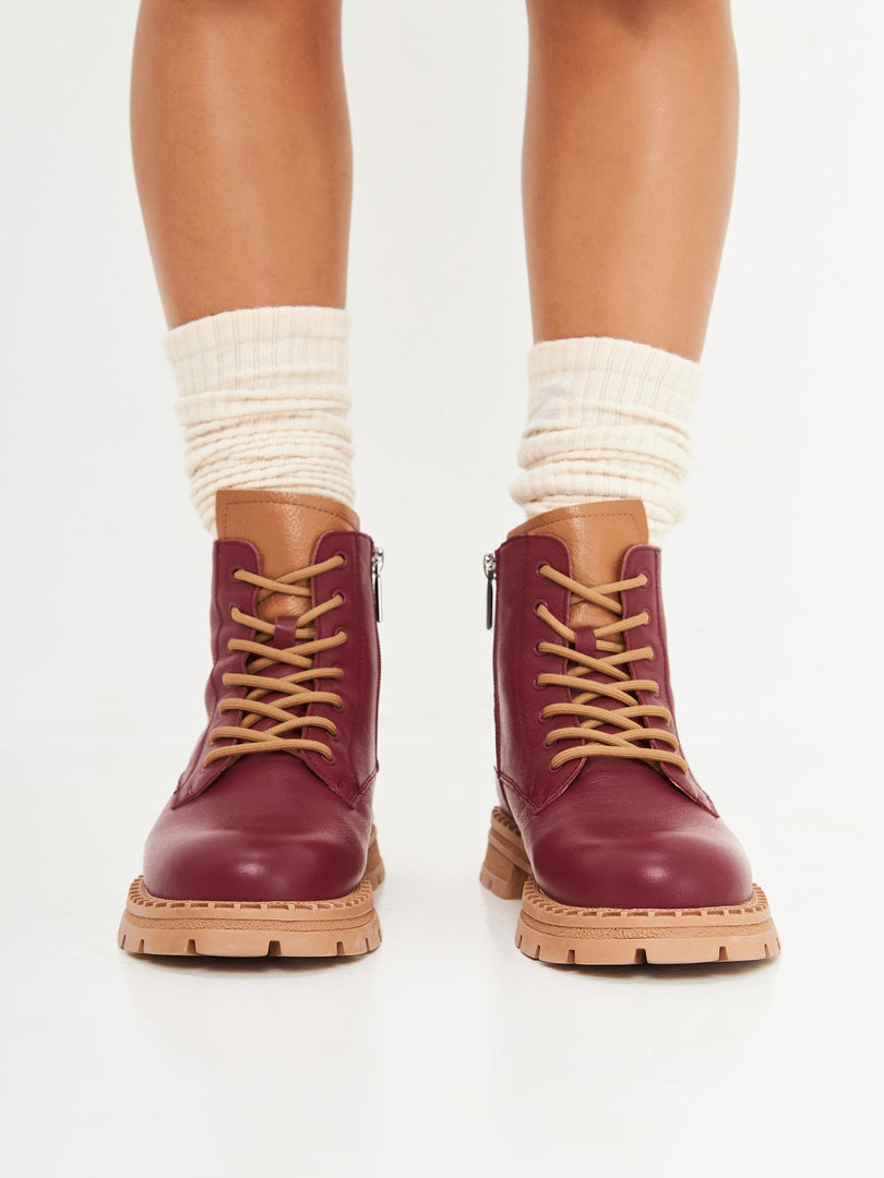 A stylish pair of women's lace-up leather ankle boots in a rich Bordeaux color, perfect for adding a touch of fashion to your outfit.