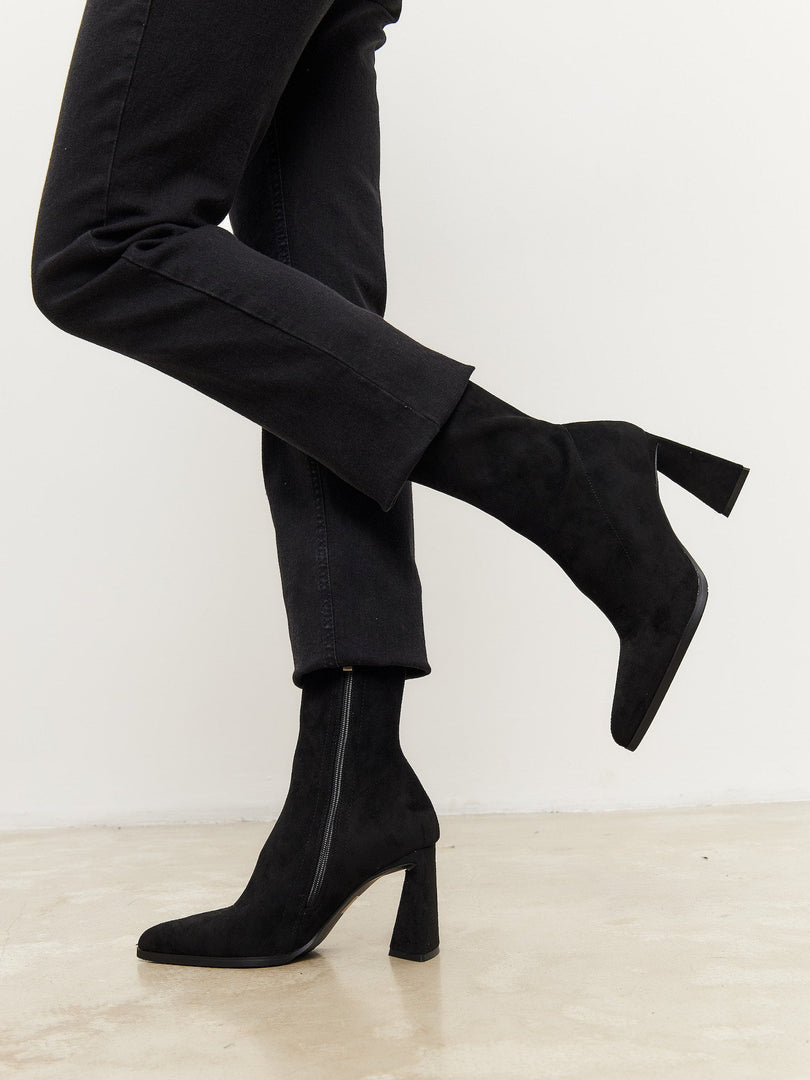 A stylish pair of suede ankle boots with block heels in black, perfect for casual wear.