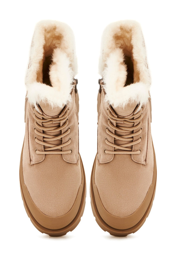 A pair of elegant beige suede ankle boots - stylish and fashionable footwear choice.