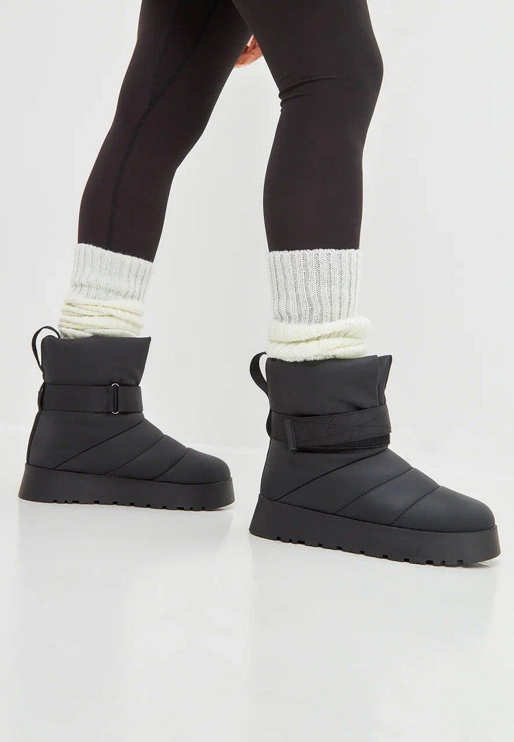 Stylish black winter boots with cozy wool lining, perfect for urban streets and chilly weather.