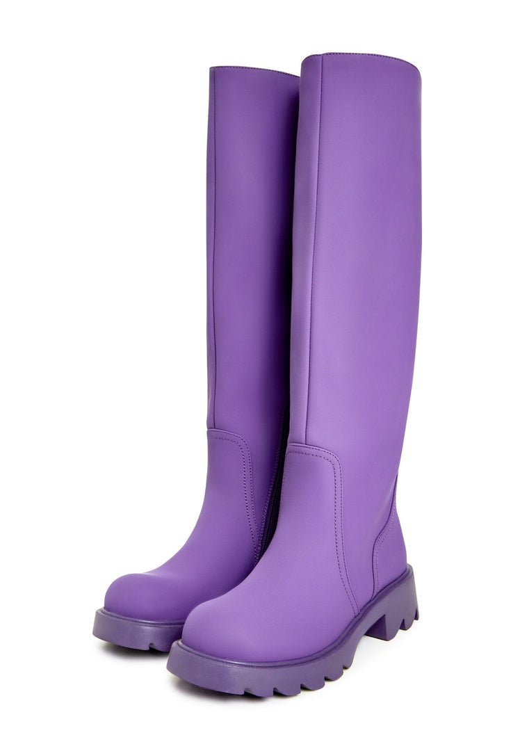 A pair of trendy knee-high chunky sole purple women's fashion boots.