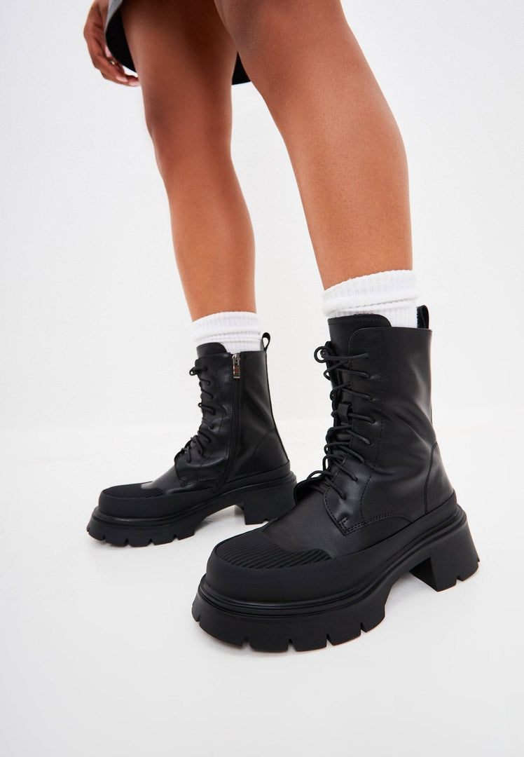 A stylish pair of black suede lace-up ankle boots, perfect for casual wear.