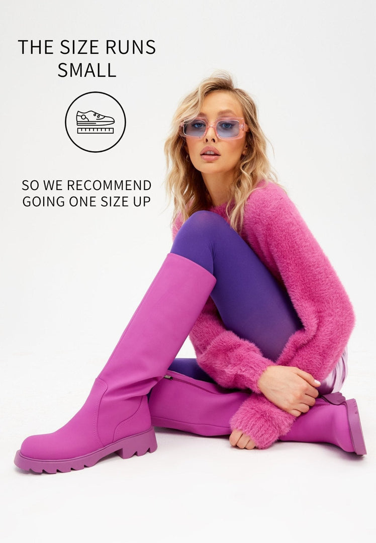 A pair of trendy knee-high pink boots with chunky soles, perfect for women's fashion footwear.