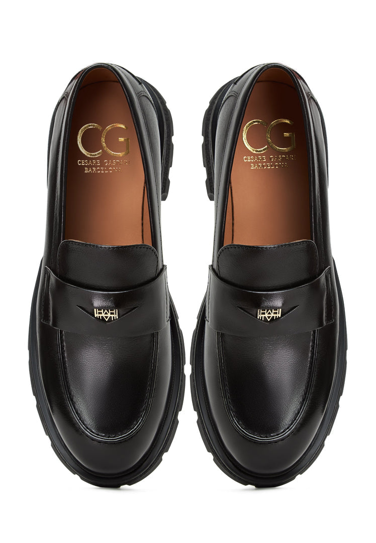 A pair of stylish Mariana black leather loafers with platform soles, making them a fashionable choice in women's footwear.