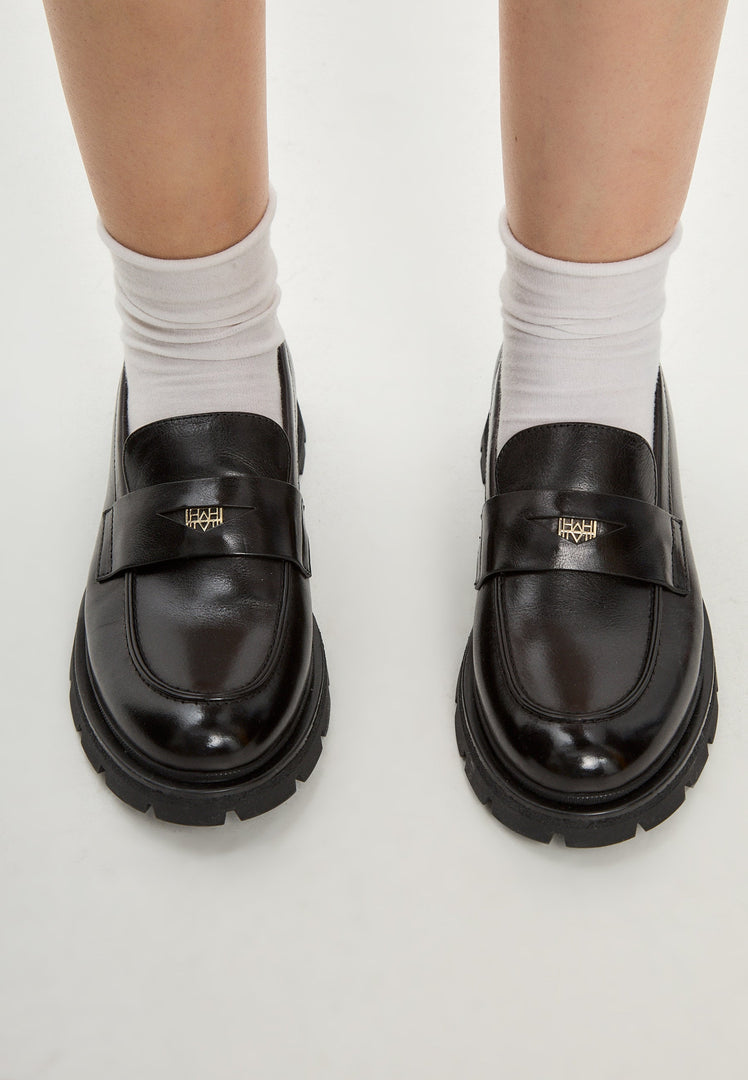 A stylish pair of Mariana black leather loafers with platform soles, perfect for women's footwear fashion.