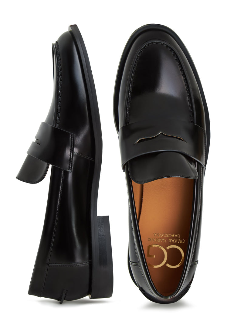 A stylish pair of patent black loafers and leather block heels, perfect for women looking for fashionable and comfortable black patent shoes.