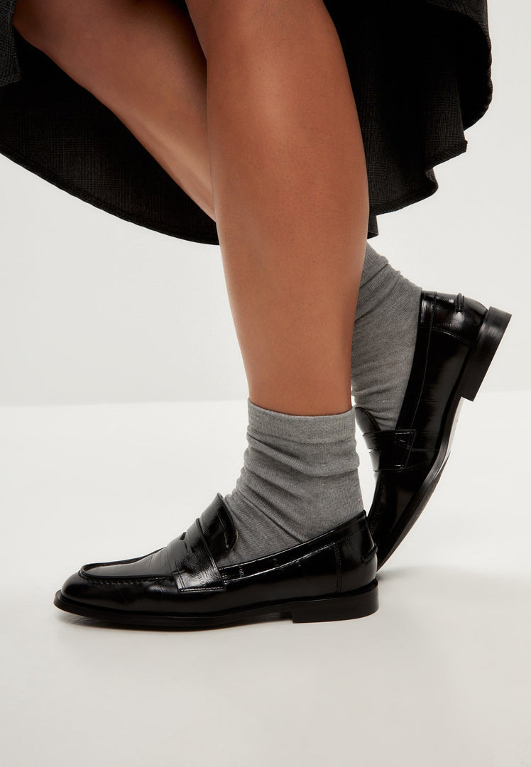 A stylish pair of women's block heeled loafers in black patent leather, perfect for any outfit.