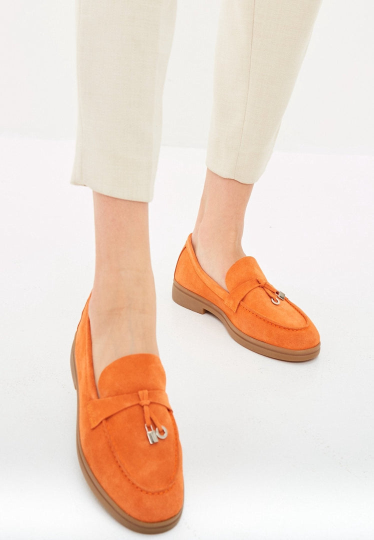 A stylish pair of men's classic loafers in vibrant orange color with a flat sole, perfect for fashion-forward footwear enthusiasts.