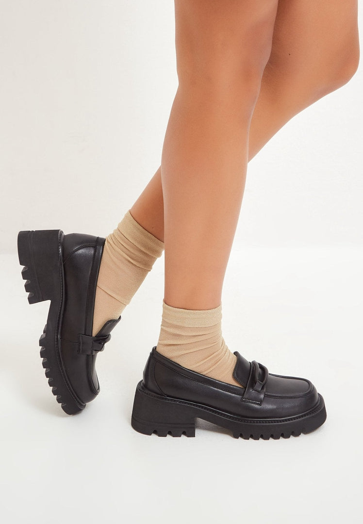 A stylish collection of women's shoes including leather loafers, classic black heels, block heel shoes, and black leather loafers for women.