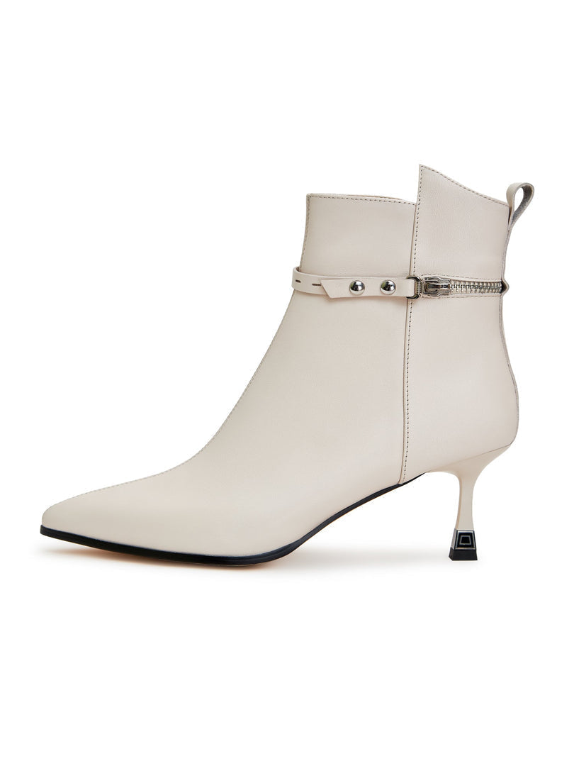 A woman wearing stylish high-heeled leather ankle boots, perfect for any fashionable outfit.