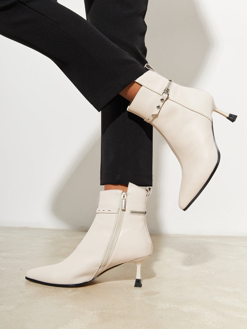 A pair of fashionable high-heeled leather ankle boots for women, perfect for a stylish and chic look.