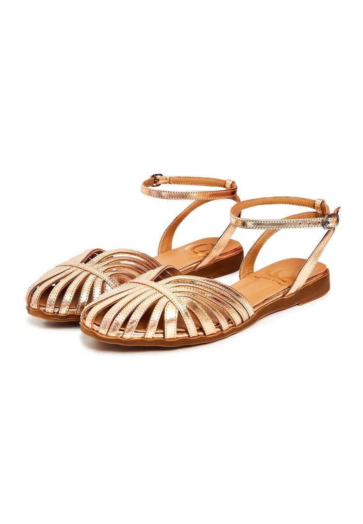 A pair of stylish gold leather flat sole sandals for women, perfect for summer days out.
