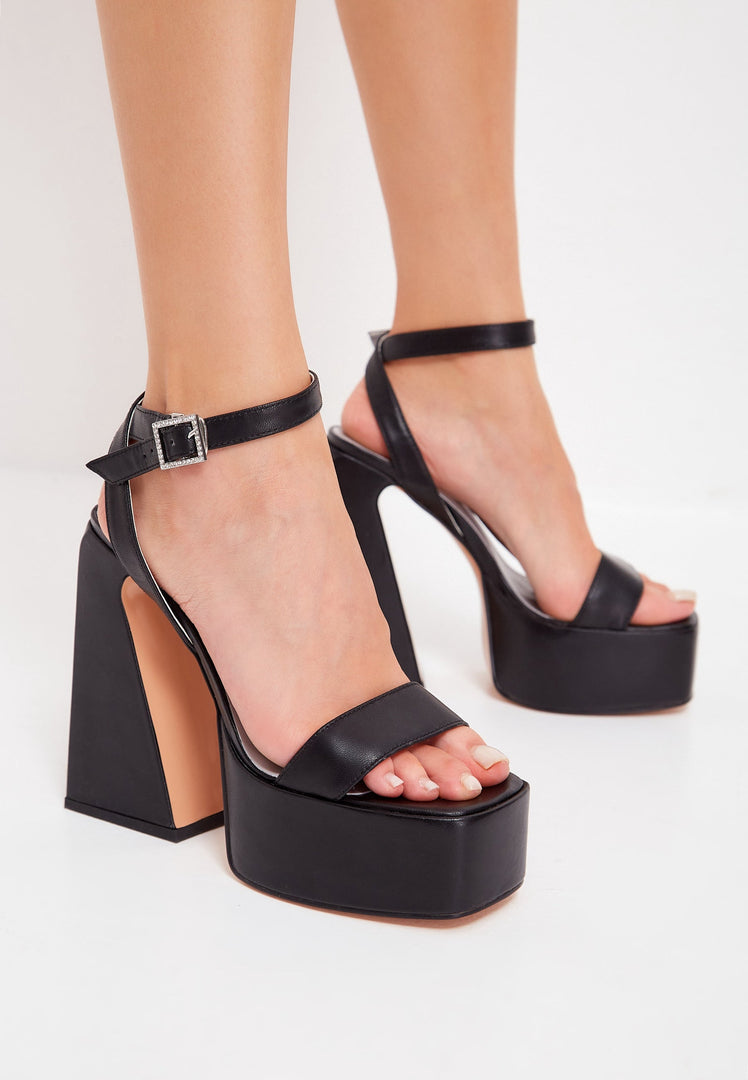A pair of elegant black elevated sandals with a stylish design.
