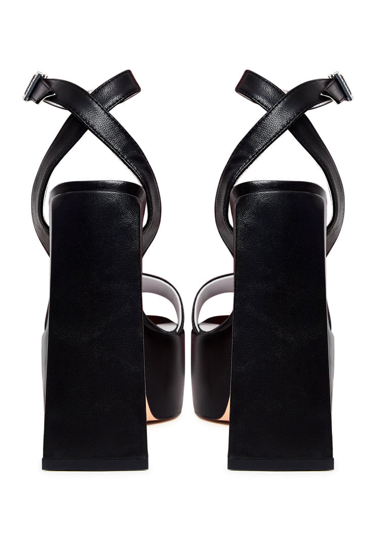 A pair of elegant black sandals with an elevated design.
