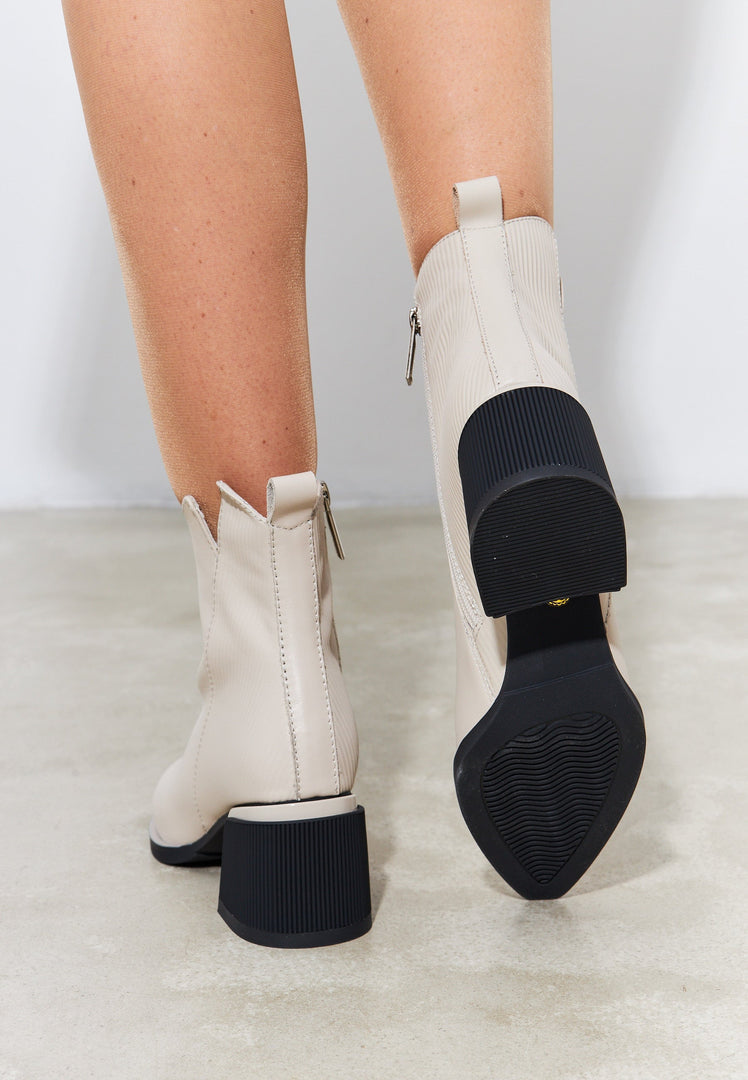 A pair of stylish beige women's ankle boots, perfect for a casual and fashionable look, designed for both style and comfort.