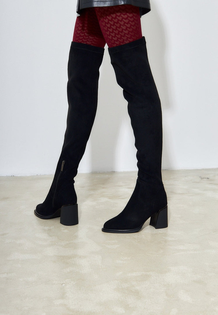 A stylish pair of leather stiletto boots that are daring and trendy women's fashion footwear.