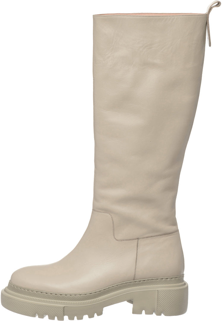 A pair of trendy tall leather chunky sole beige women's boots - stylish fashion footwear.