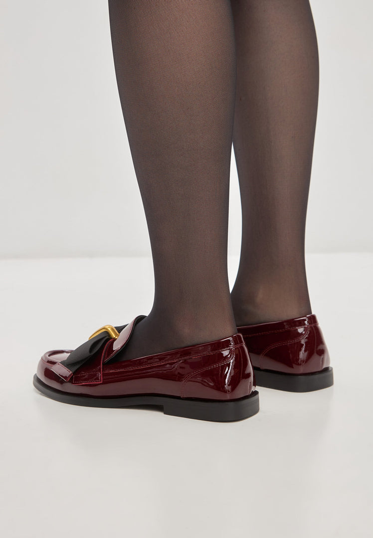 A stylish collection of women's dress shoes, including elegant loafers, black bow loafers, Dorothy loafers, and patent red shoes displayed on a white background.