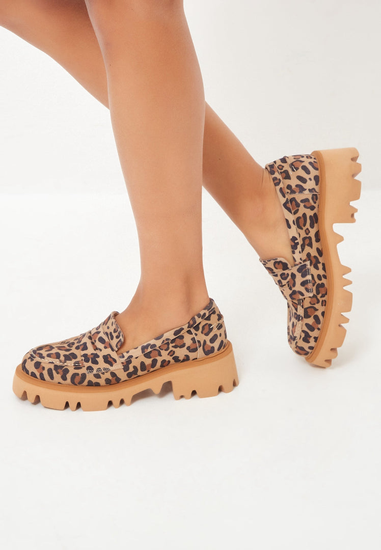 A pair of women's chunky platform loafers in trendy leopard print, making a bold statement with these animal print shoes.