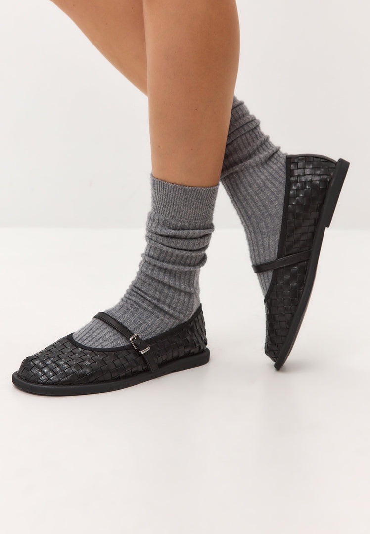 A stylish pair of black Woven Elegance Mary Janes, perfect for fashionable women's footwear.