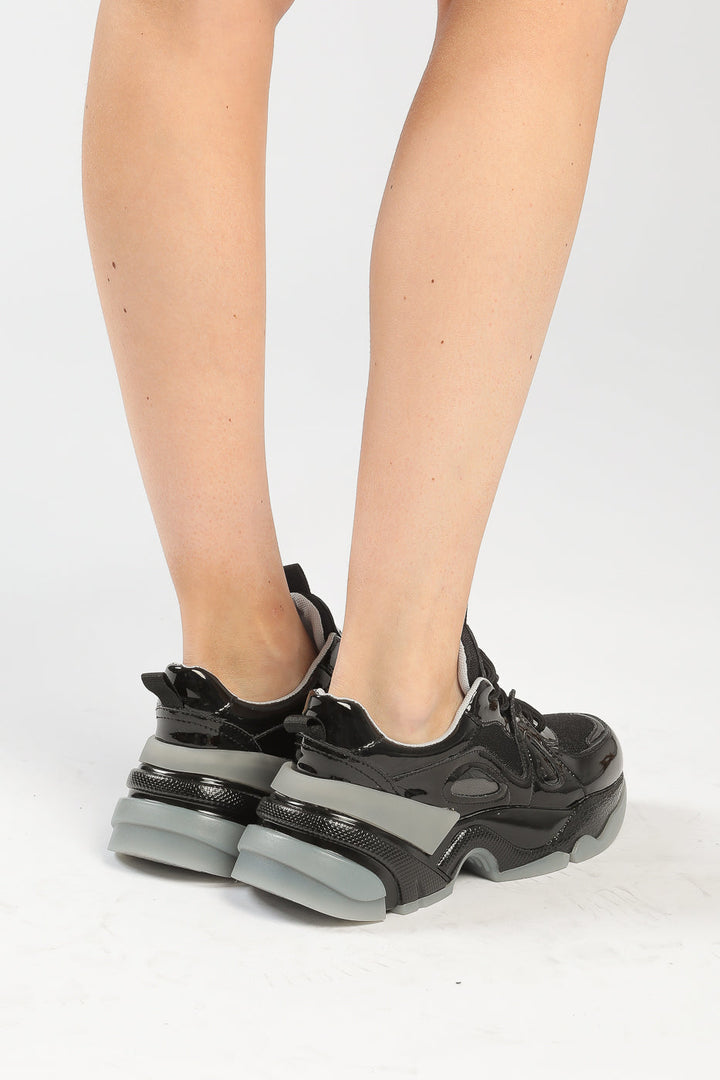 A close-up image of chunky sole glossy platform sneakers perfect for a fashion-forward and trendy look.