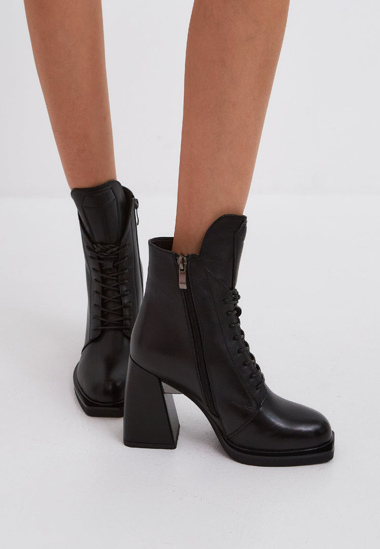 A stylish pair of black leather lace-up ankle boots, known as the Behati black boots.