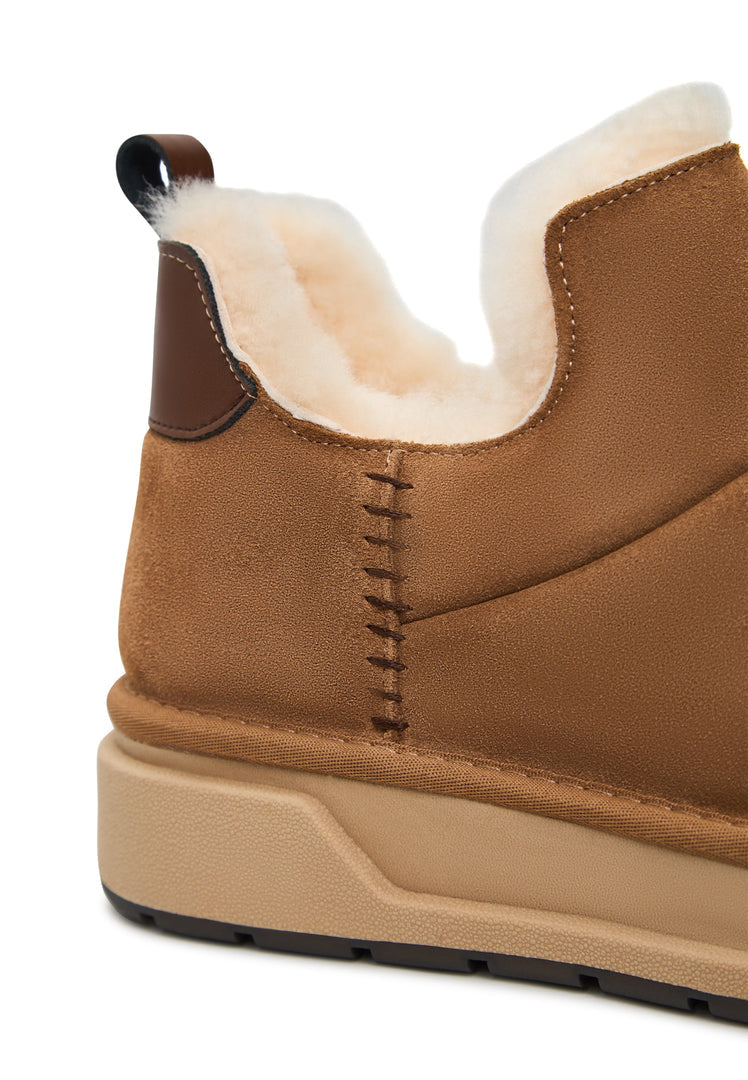 A cozy pair of brown shearling winter boots, perfect for staying warm and stylish in the snow - the must-have Aspen boots for this season.