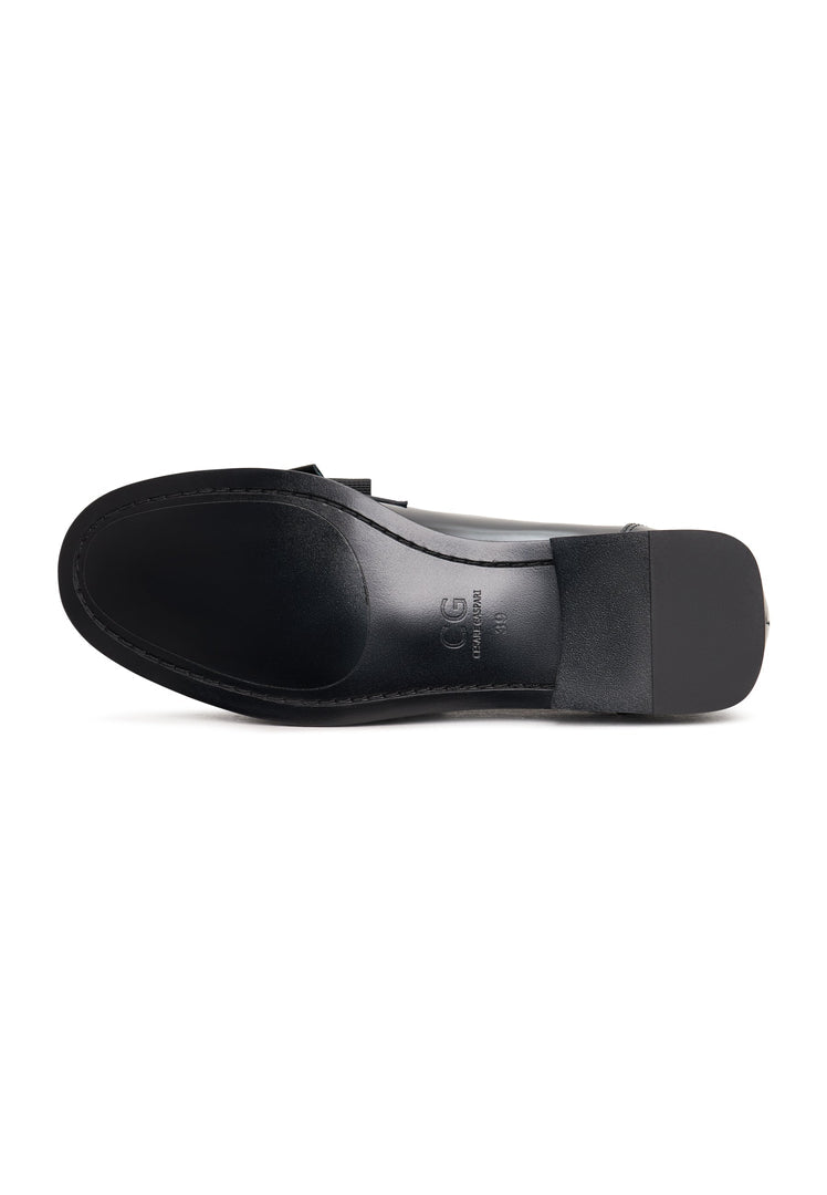 A pair of elegant patent black women's shoes with a gold bow, inspired by Dorothy's style.