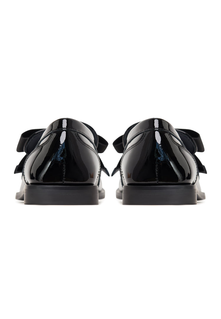 Elegant patent black women's loafers with a sophisticated gold bow detail, inspired by Dorothy's classic style.