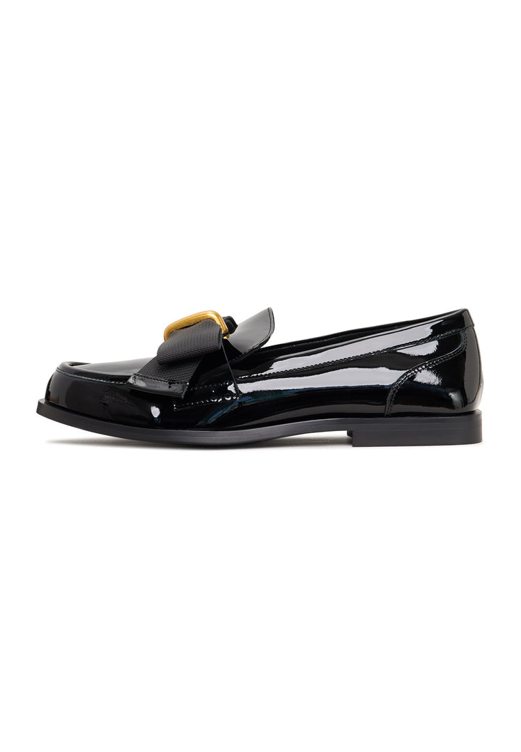 A pair of elegant black patent loafers with a stunning gold bow detail, inspired by Dorothy's iconic shoes, perfect for women's fashion.