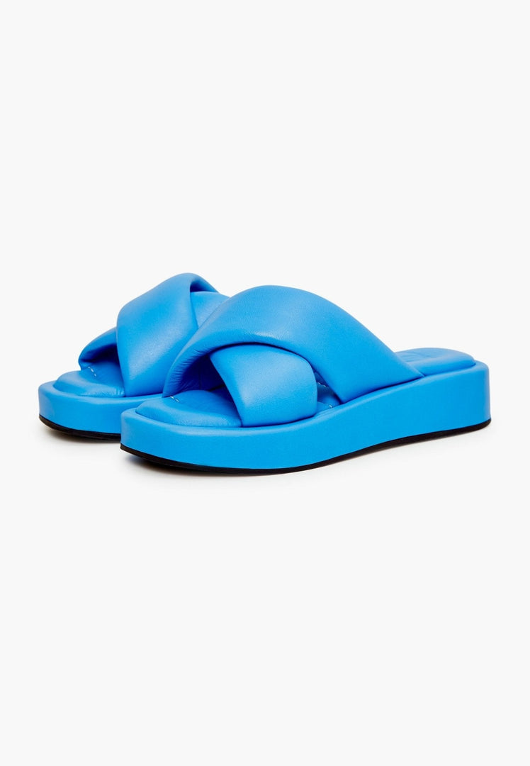A stylish pair of women's blue leather platform mule shoes with high heels, perfect as a fashionable leather slide sandal option.