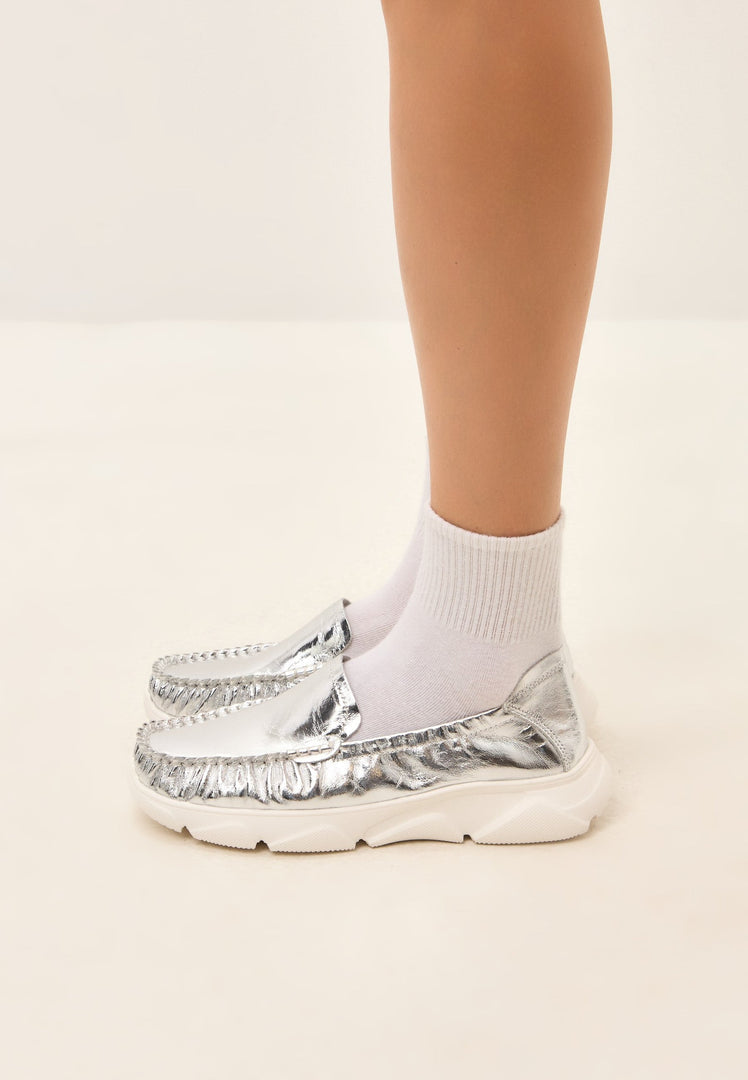 A stylish pair of silver leather platform moccasins, the Alisa moccasins, perfect for adding a touch of glamour to any outfit.