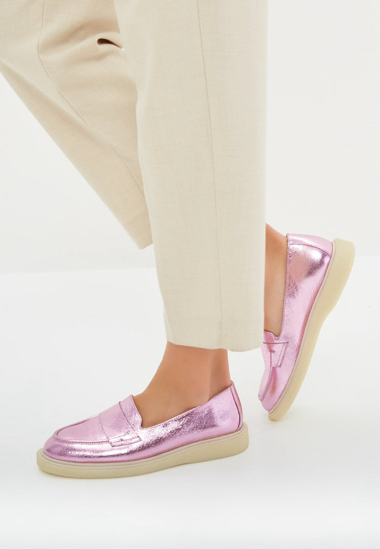 A stylish pair of metallic pink women's loafers with a flat sole, perfect for fashionable footwear enthusiasts.