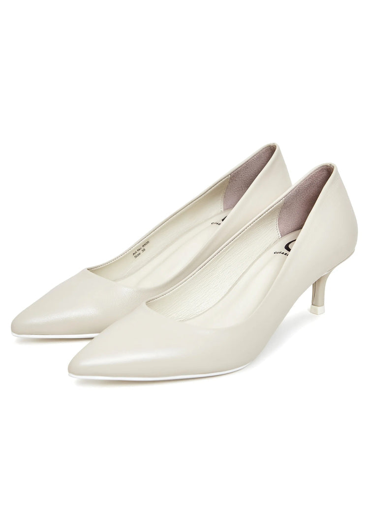 A pair of elegant luxe off white pumps, perfect for a luxurious occasion like a white wedding, designed by a high-end designer.