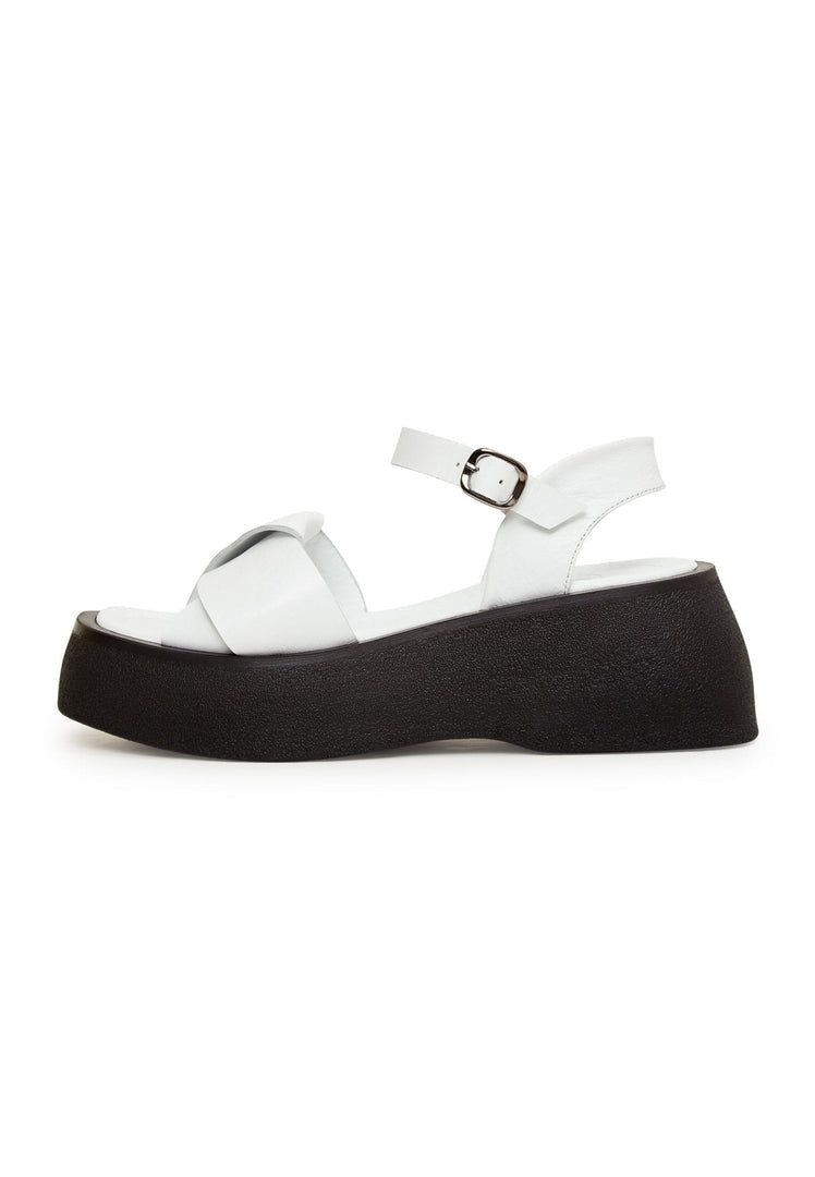 A pair of stylish white leather platform sandals, perfect for summer outings and adding a touch of elegance to any outfit.