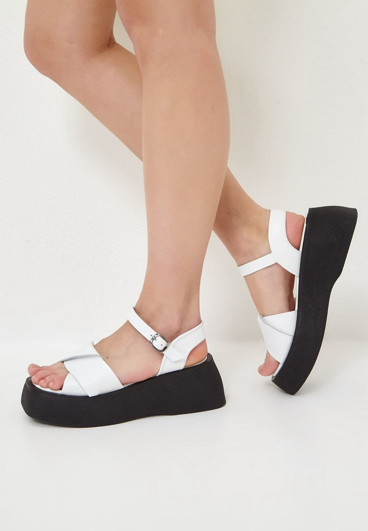 A stylish pair of white leather platform sandals with a trendy design, perfect for summer outings.