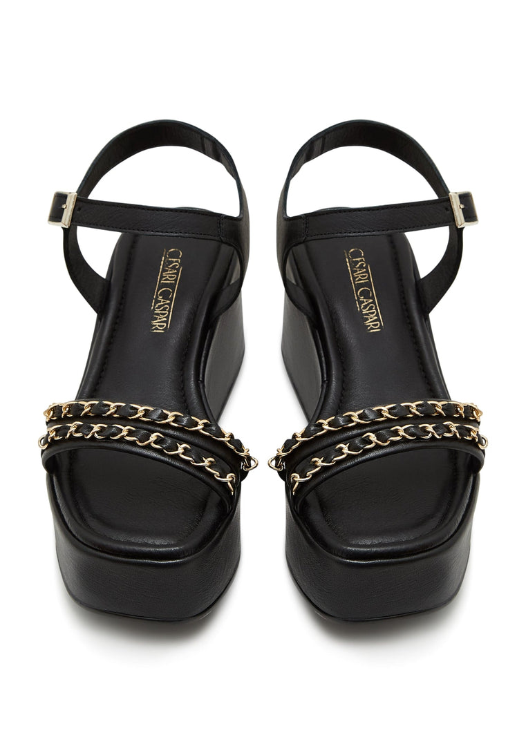 A stylish pair of black platform sandals for women with chic gold chain accents, perfect for trendy and fashionable shoe lovers.