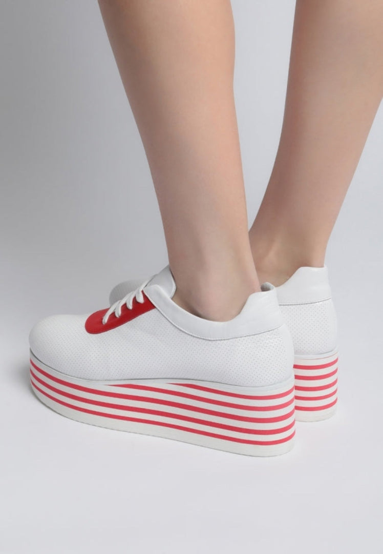 A stylish pair of red high platform sneakers with striped detailing, perfect for adding a trendy touch to any outfit.