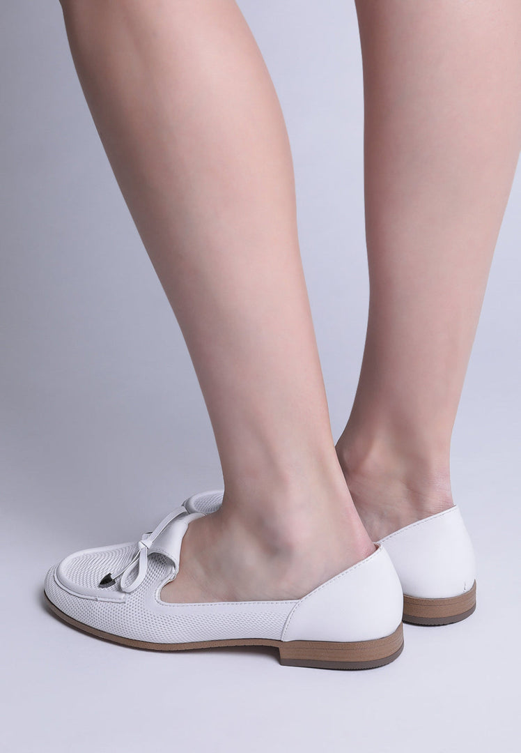 A pair of stylish white loafers with a perforated bow-tie design, perfect for men's formal attire.