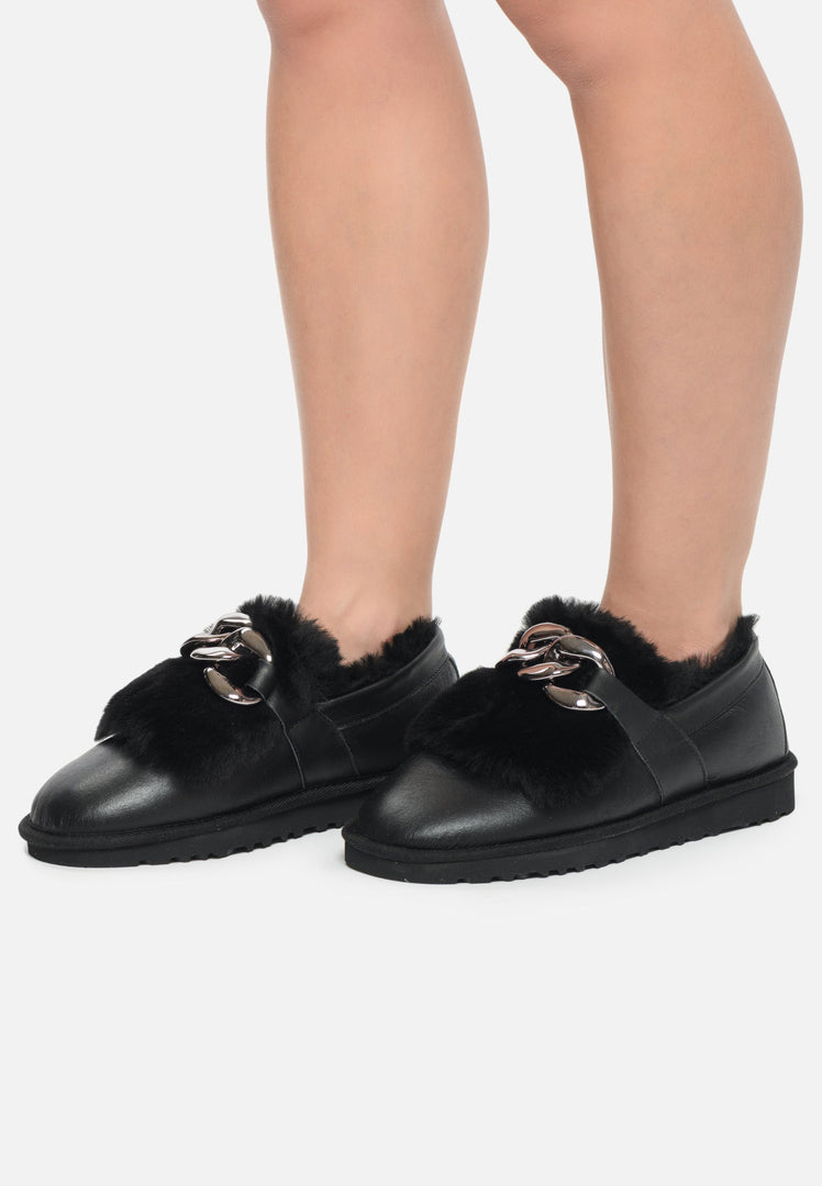 A pair of trendy black fur-lined loafers with chain detail, perfect for women's winter style as stylish casual footwear.
