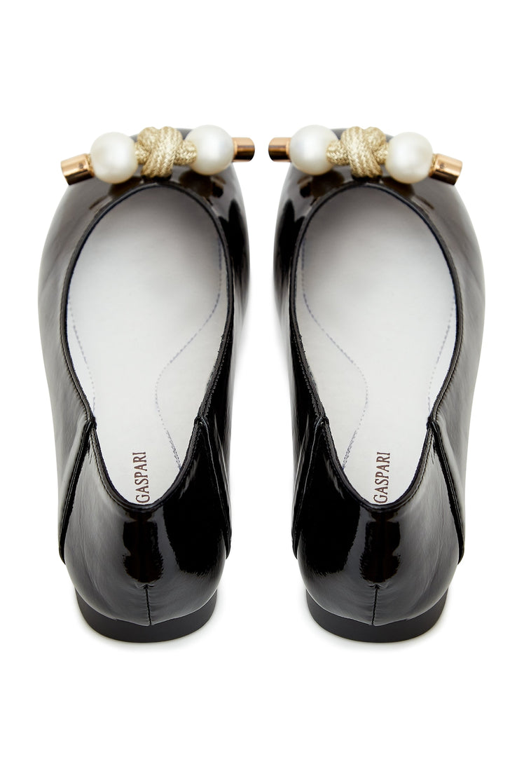 A stylish pair of women's bow flats in black, adorned with elegant pearl embellishments, perfect for a fashionable and chic look.