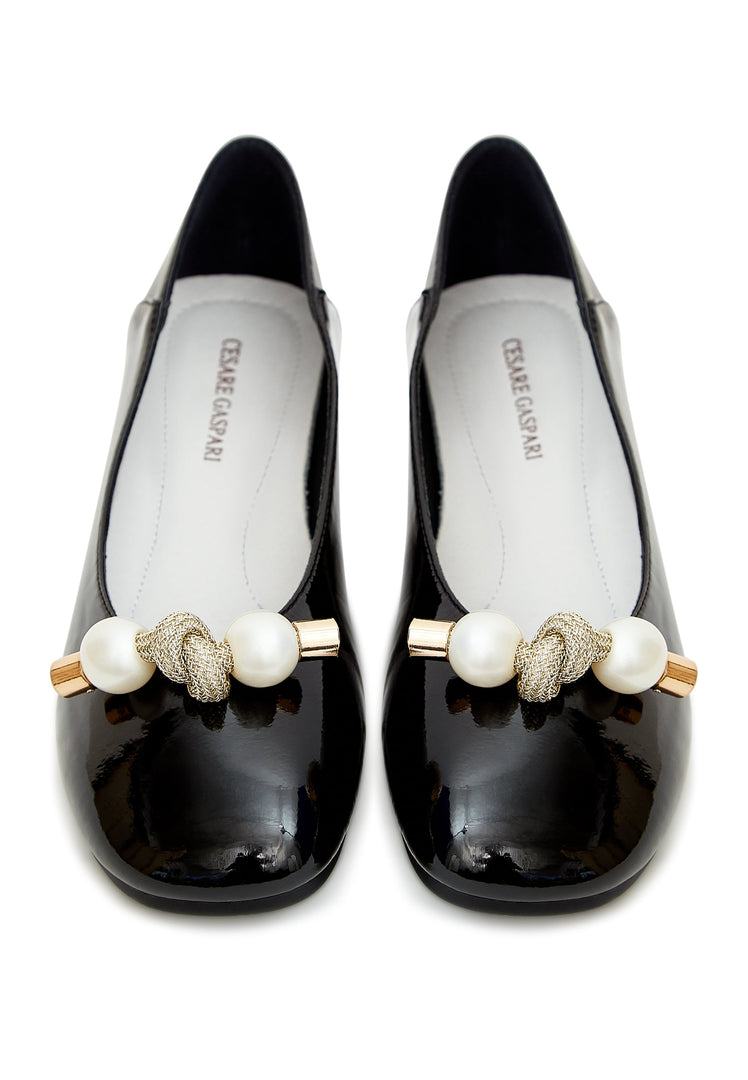A stylish pair of women's black flats with a charming pearl bow embellishment, perfect for adding a fashionable touch to any outfit.