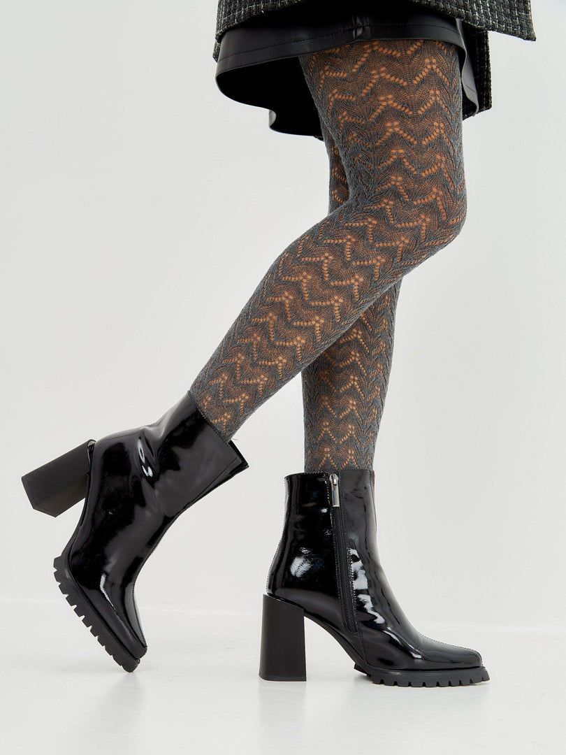 A stylish pair of women's black patent leather ankle boots, a classic choice in footwear fashion.