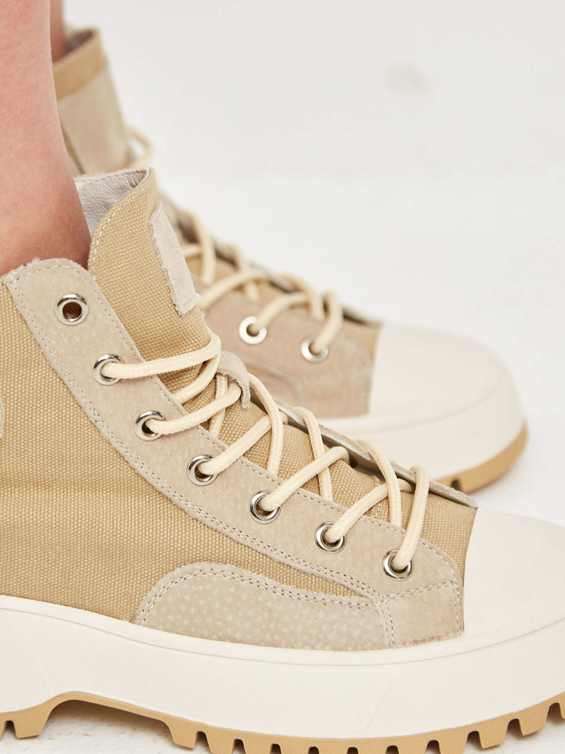 A close-up image of lace-up high top sneakers with textured detailing, perfect for a stylish and sporty look.
